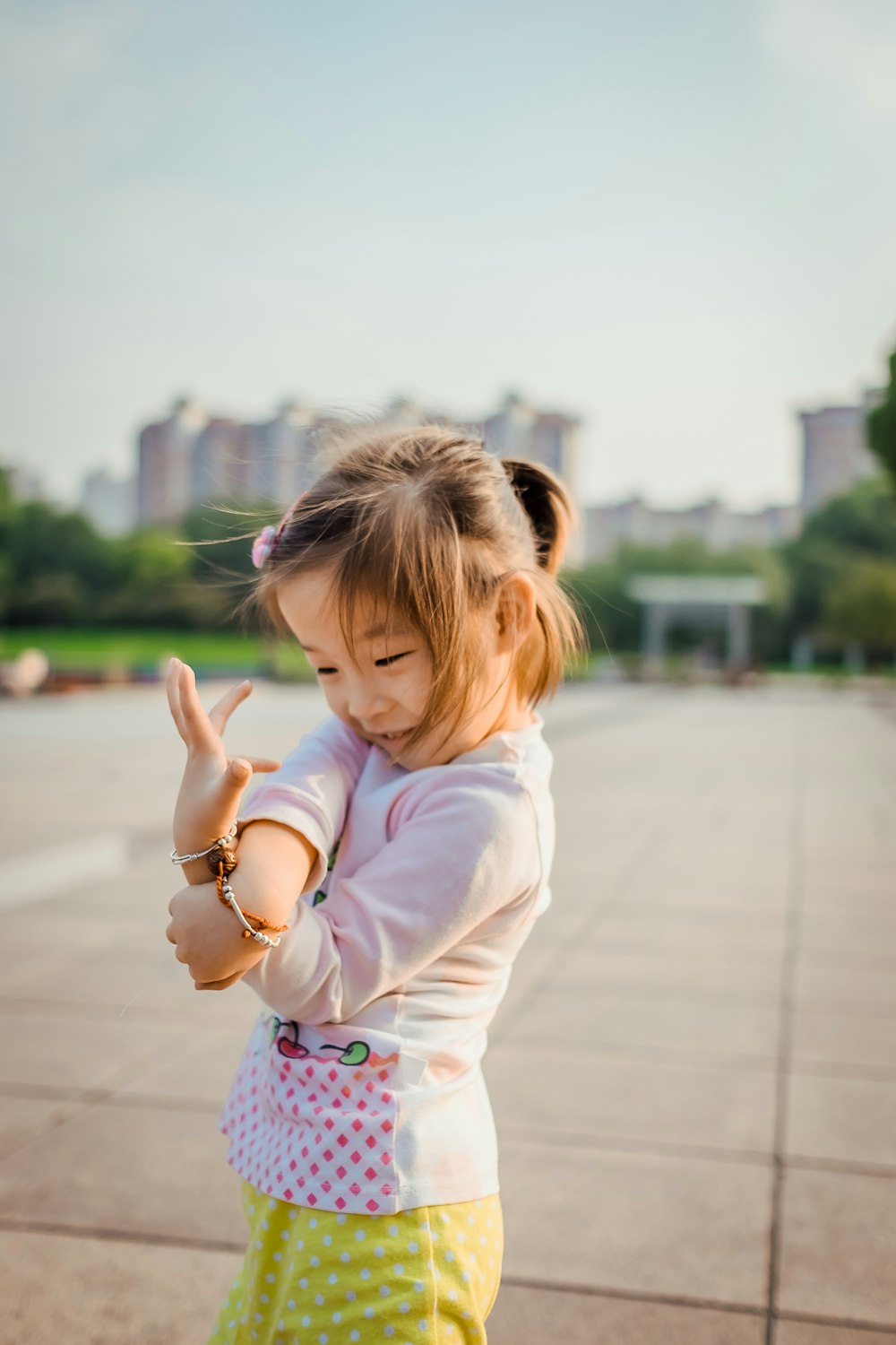 smiling girl standing and twisting both hands