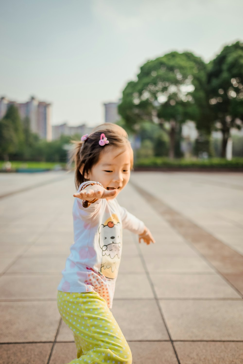 girl wearing white and pink bear graphic long-sleeved shirt outdoor