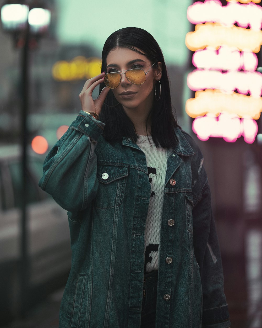 woman standing outdoors touching glasses