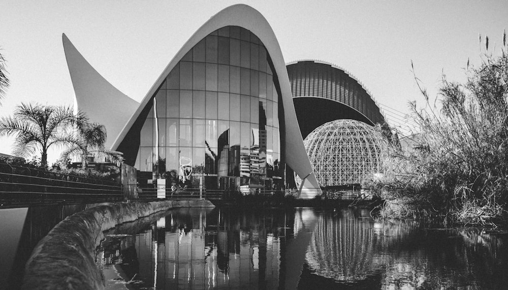 grayscale photography of building beside of body of water