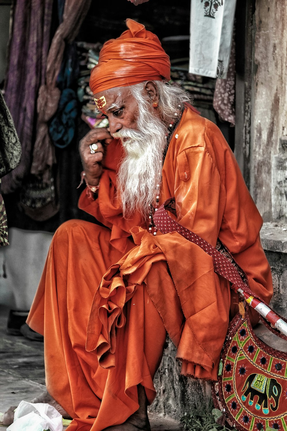 man wearing red robe sitting on stair