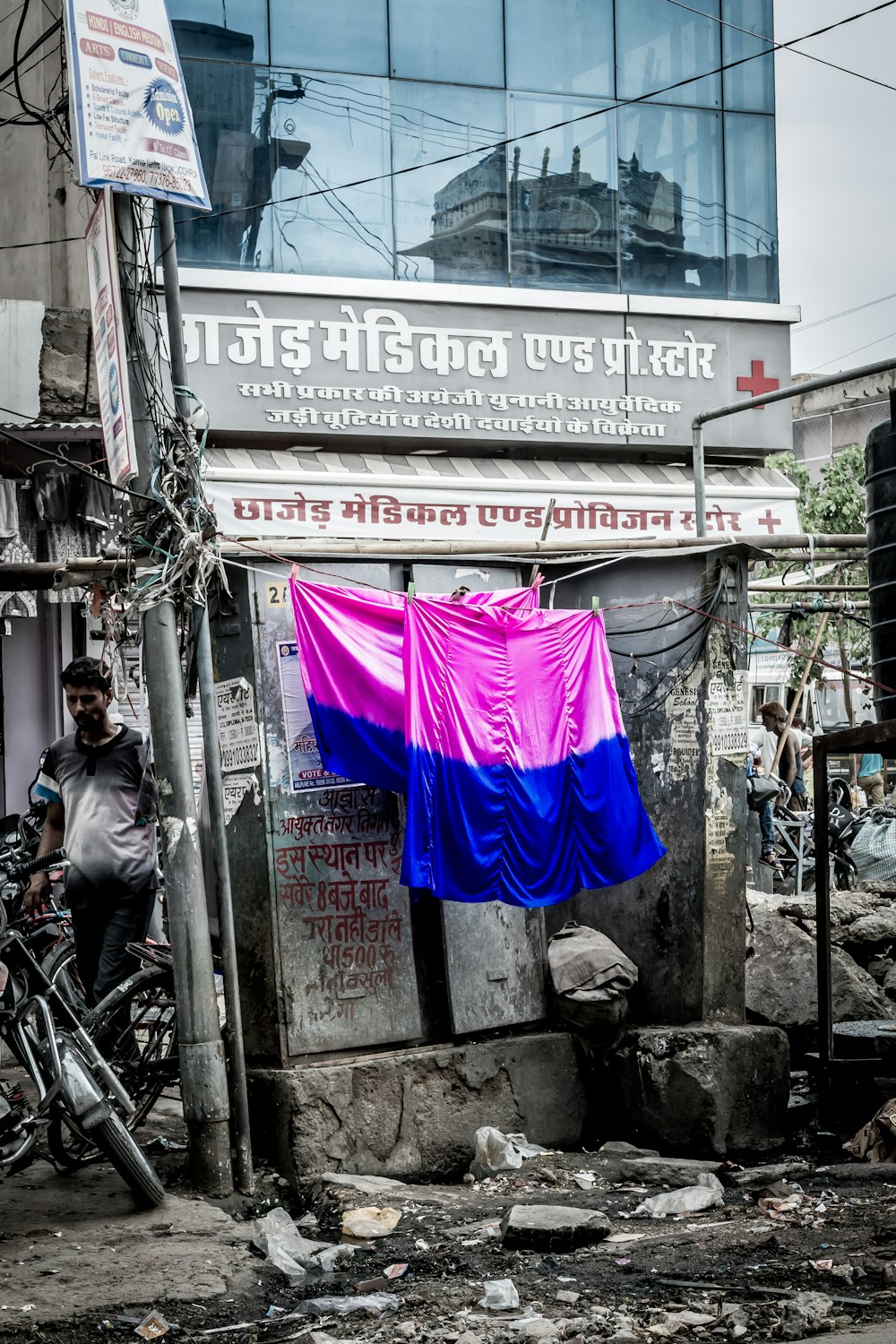 two pink-and-blue textiles hanging beside building