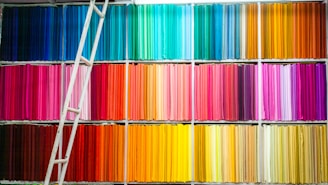 Stacks of colorful eco-friendly textile rolls in a bright workshop.