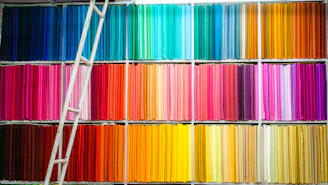 A vibrant display of colorful telescopic ladders neatly arranged in a bright showroom.