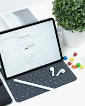 a tablet computer sitting on top of a desk next to a keyboard