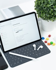 a tablet computer sitting on top of a desk next to a keyboard