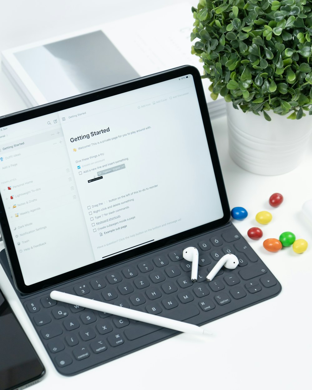 a tablet computer sitting on top of a desk next to a keyboard