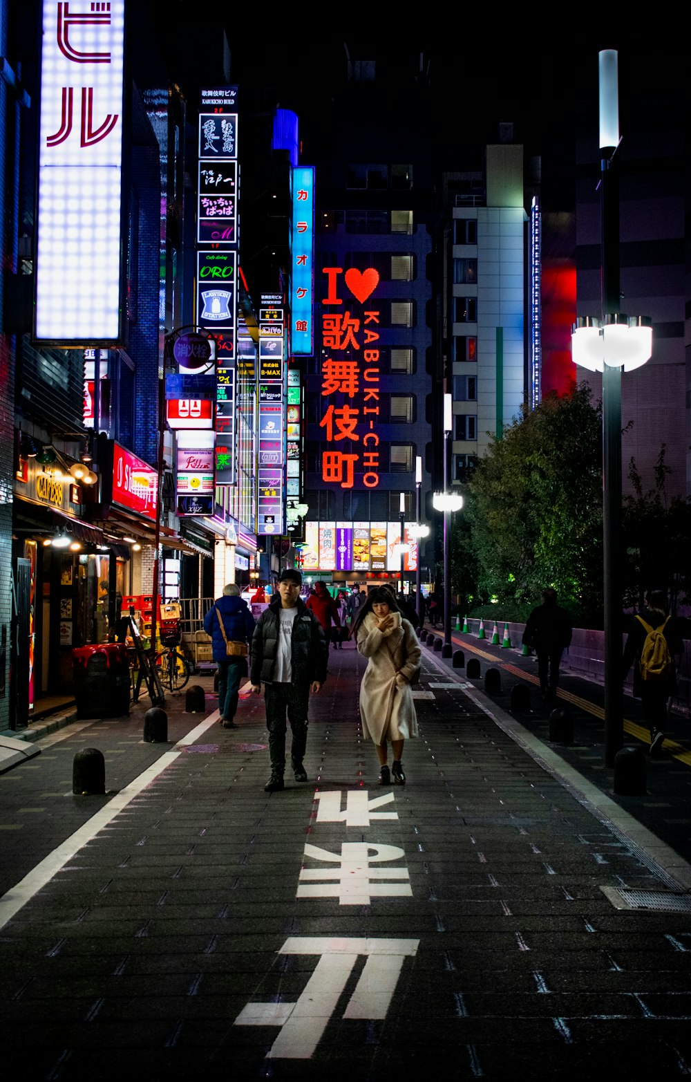 夜の路上で女性のそばに立つ男性