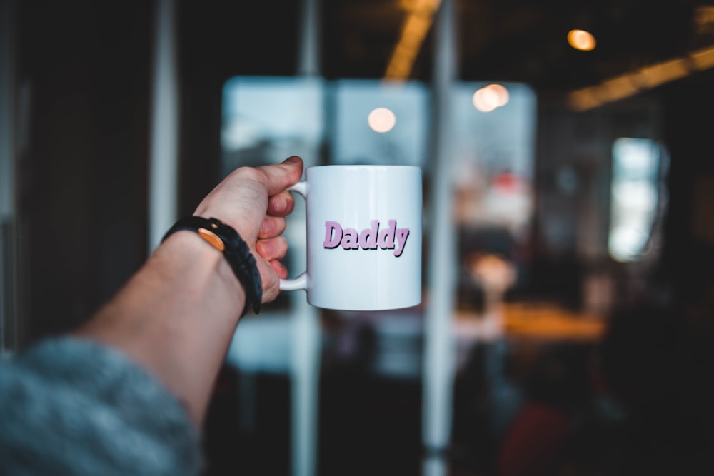 person holding ceramic mug