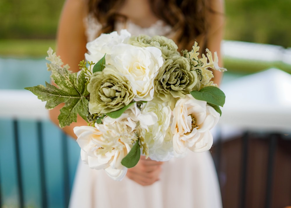 woman wearing white bridal gown holding white and green flower bouquet