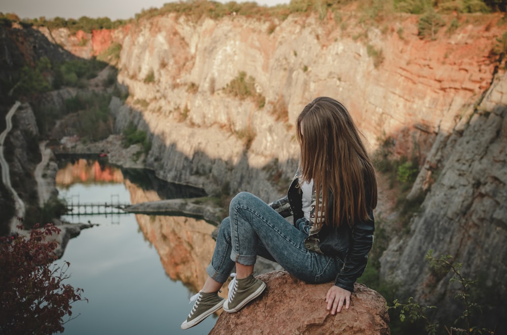 woman sitting down on rock