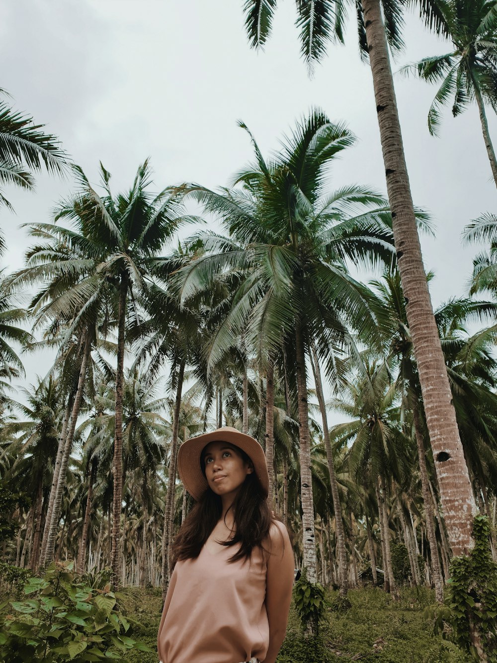 woman standing beside coconut trees