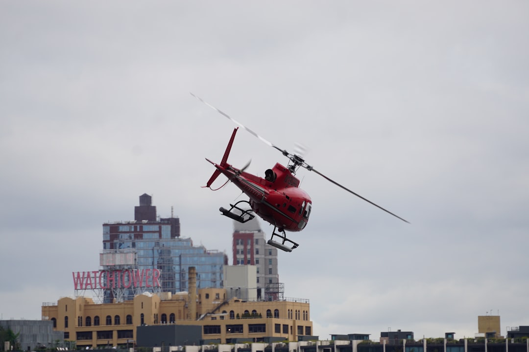 flying red helicopter during daytime