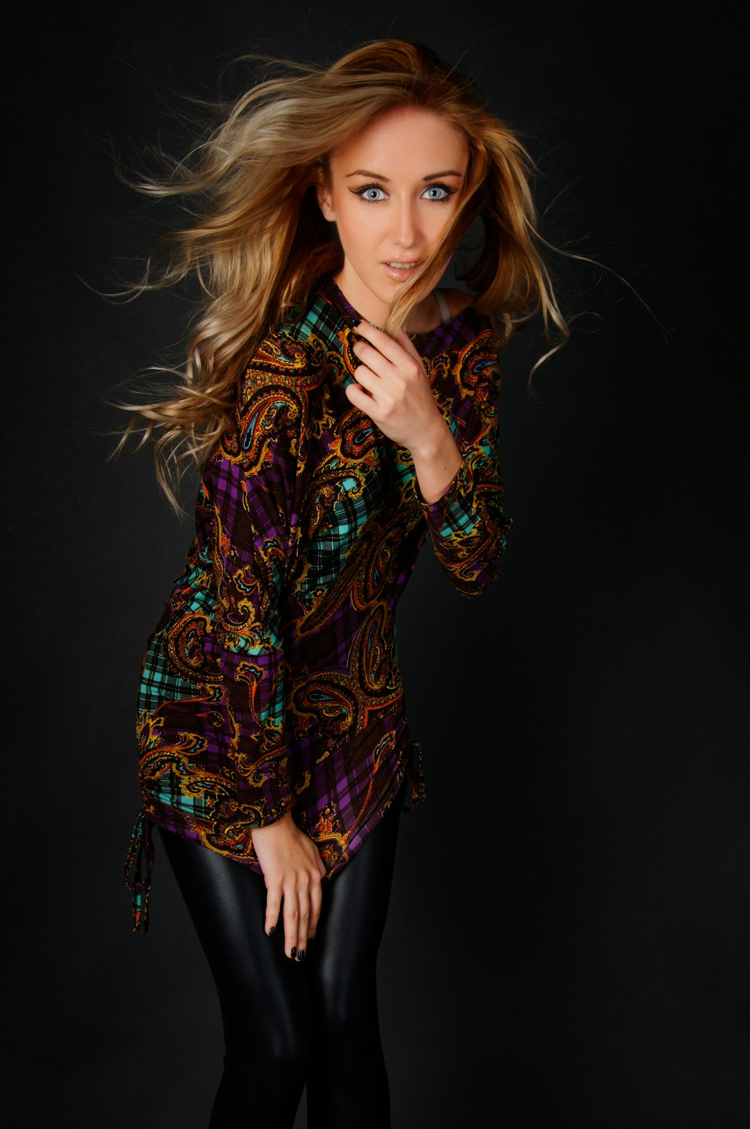 woman wearing multicolored long-sleeved top holding hair