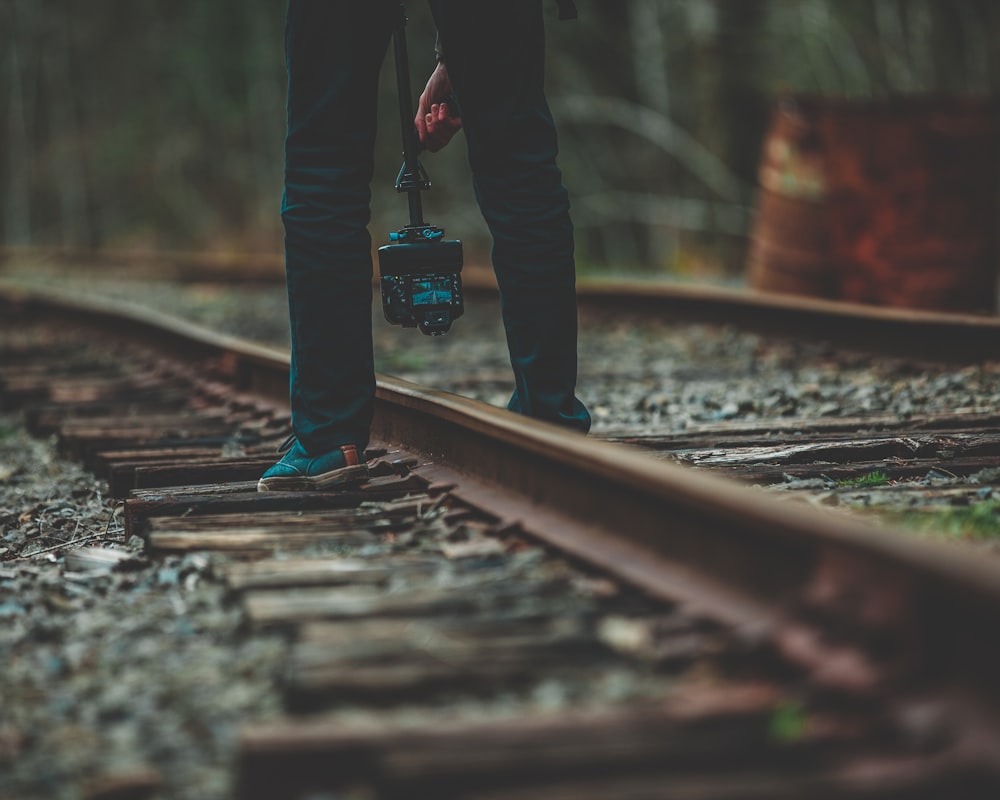 person holding lamp post standing on train railroad