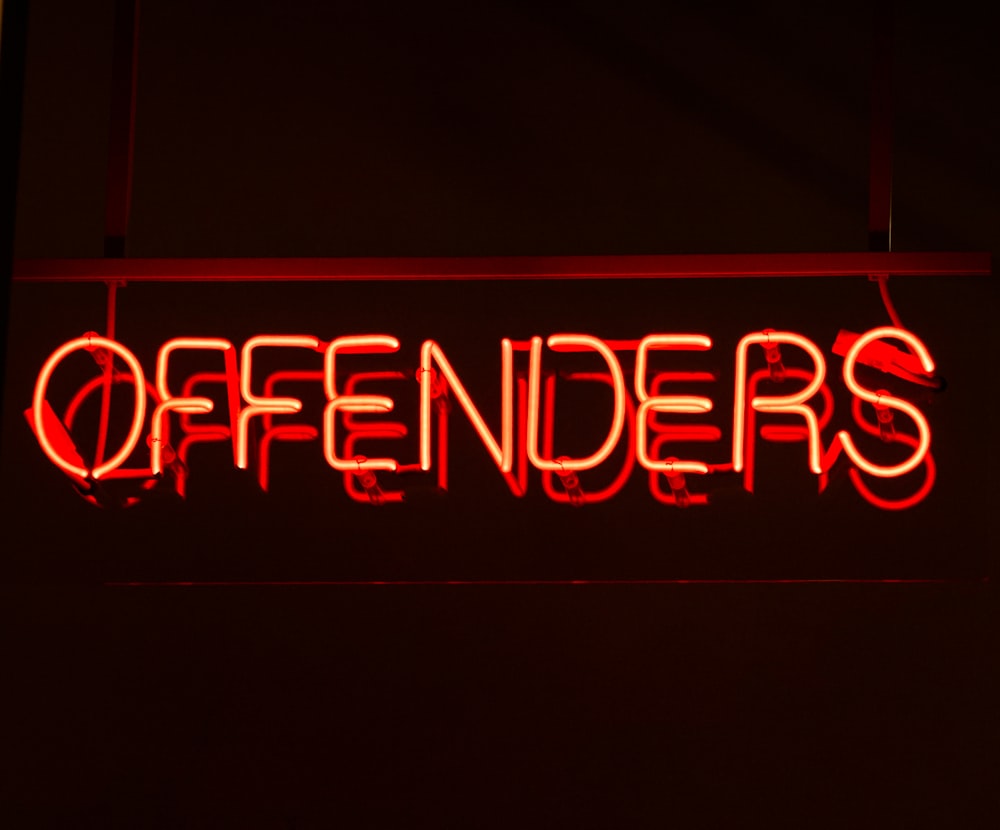 red neon lighted offenders signage