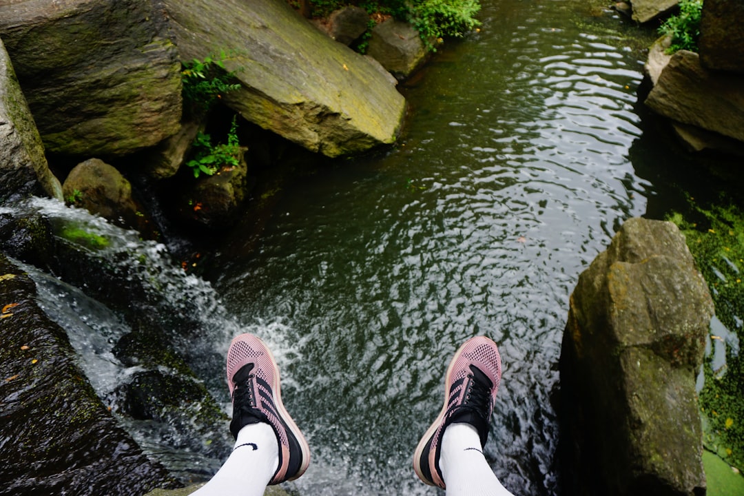 person in shoes overlooking river