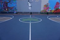 Close-up of a colorful mural blending basketball and abstract art on a court wall.
