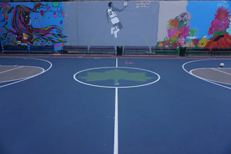Close-up of a colorful mural blending basketball and abstract art on a court wall.
