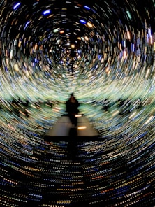a person standing in a tunnel of lights
