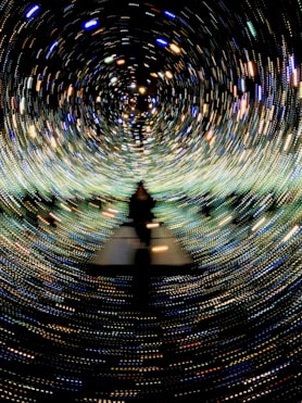 a person standing in a tunnel of lights