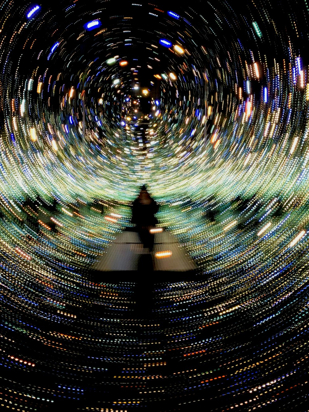 a person standing in a tunnel of lights