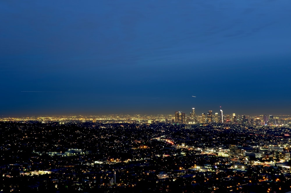 a view of a city at night from the top of a hill