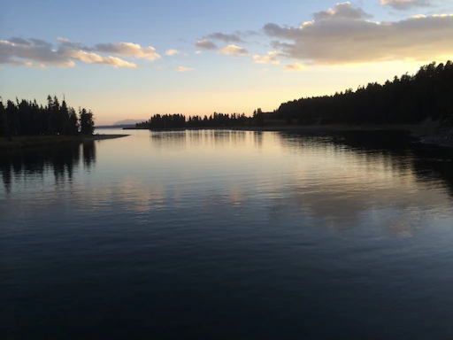 A serene Connecticut lake at sunset with gentle ripples reflecting the colorful sky.