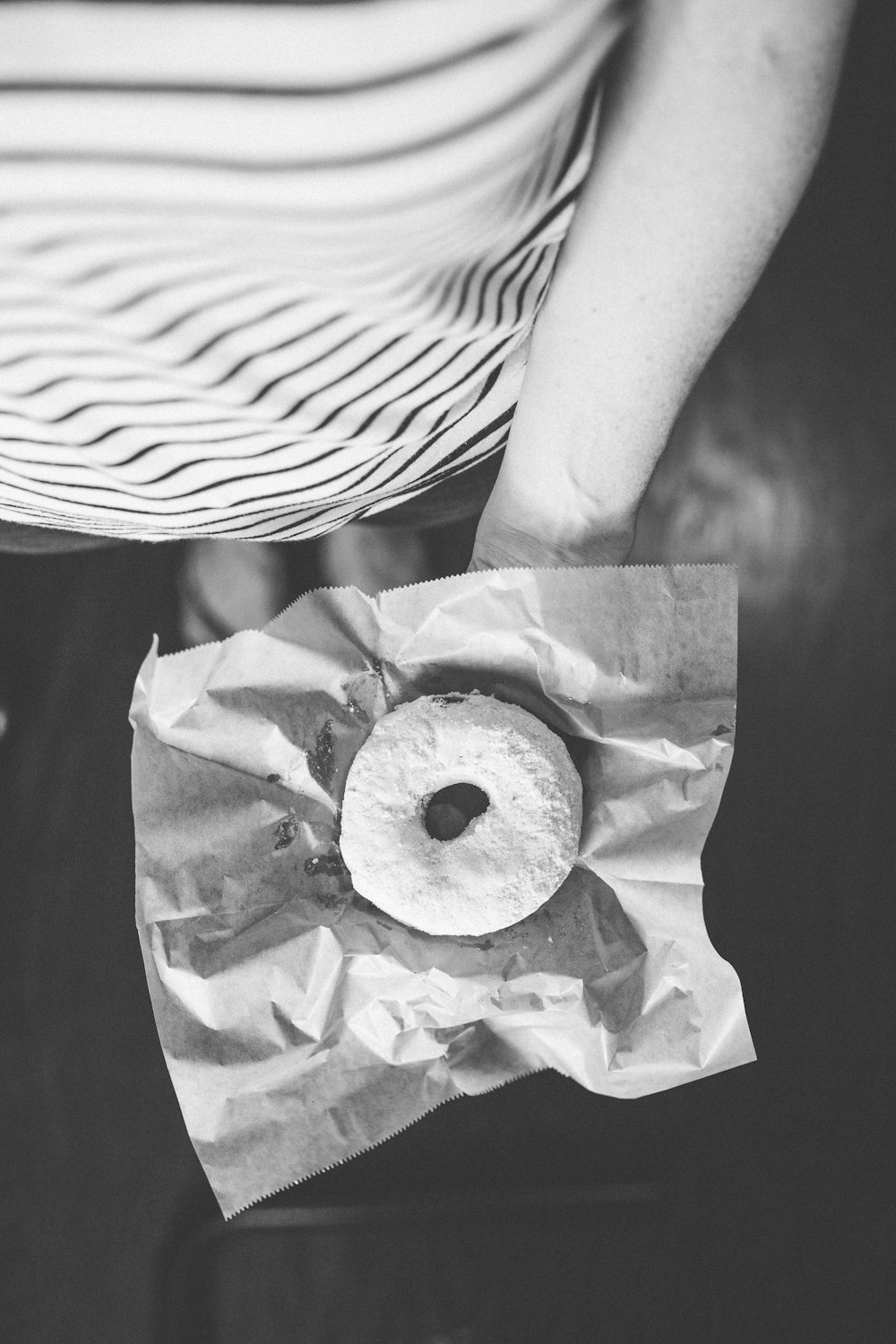 gray-scale photography of doughnut on palm