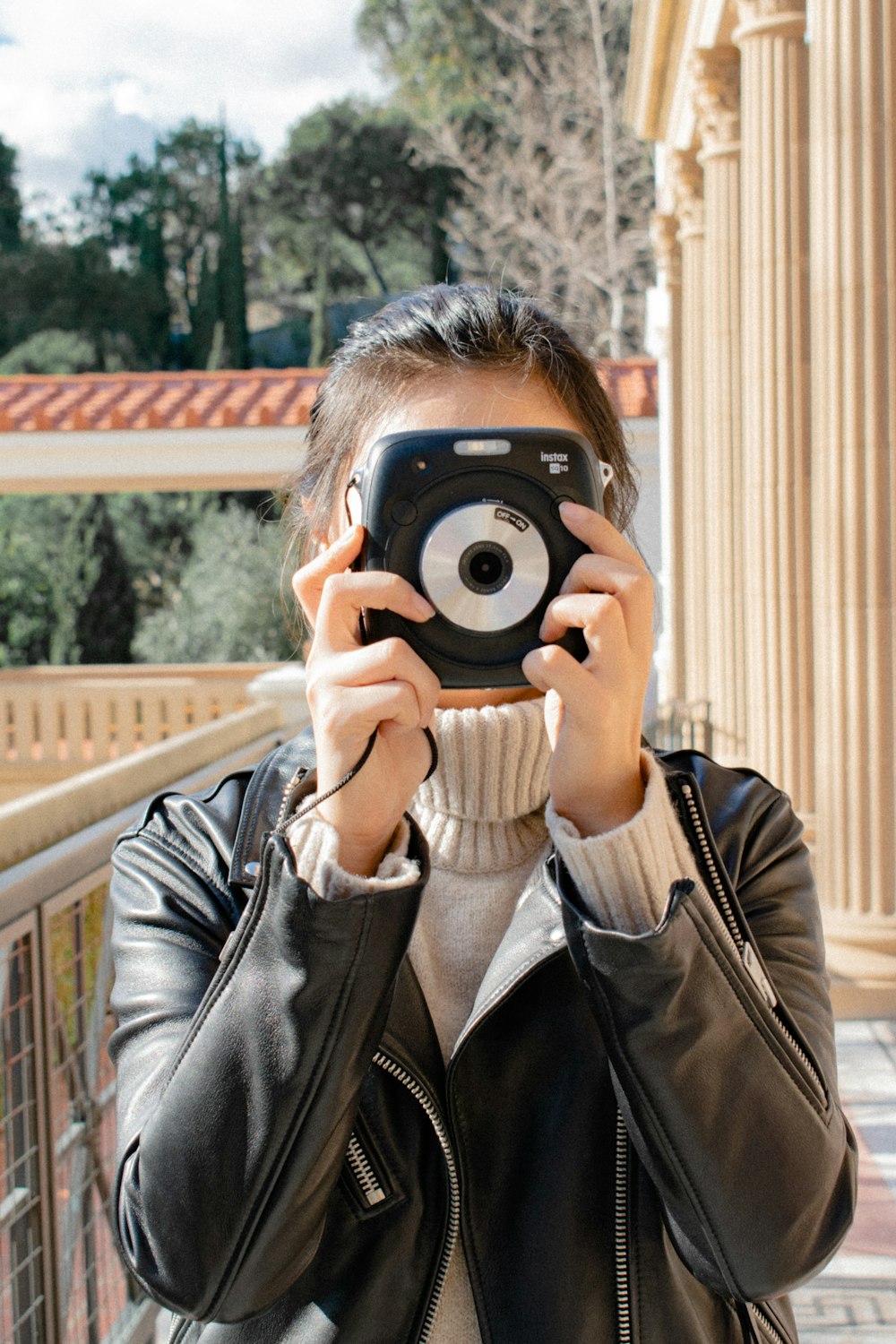 woman holding black instant camera