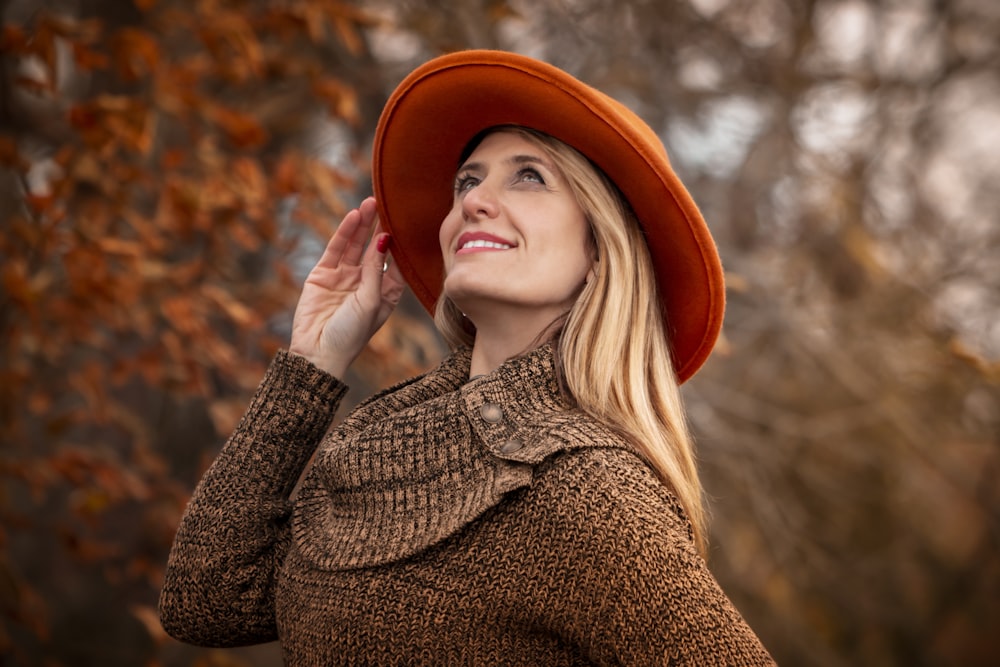 주황색 모자와 갈색 스웨터를 입고 있는 여자