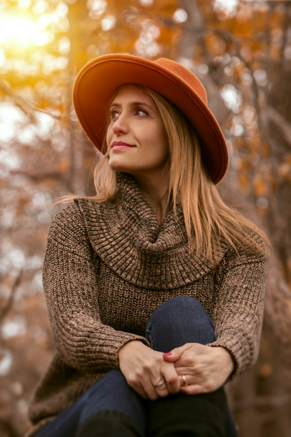 donna che indossa maglione marrone e cappello arancione