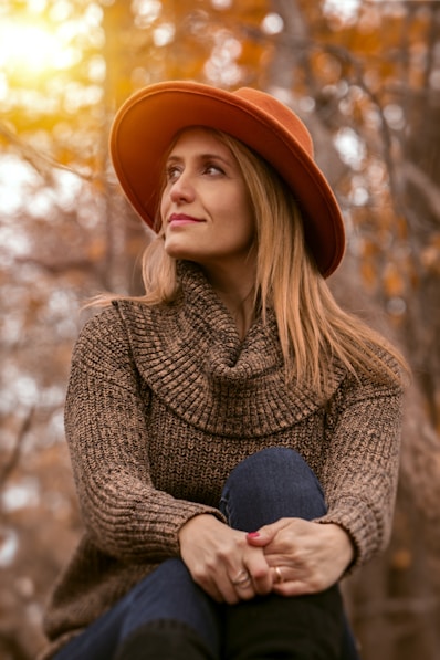 woman wearing brown sweater and orange hat