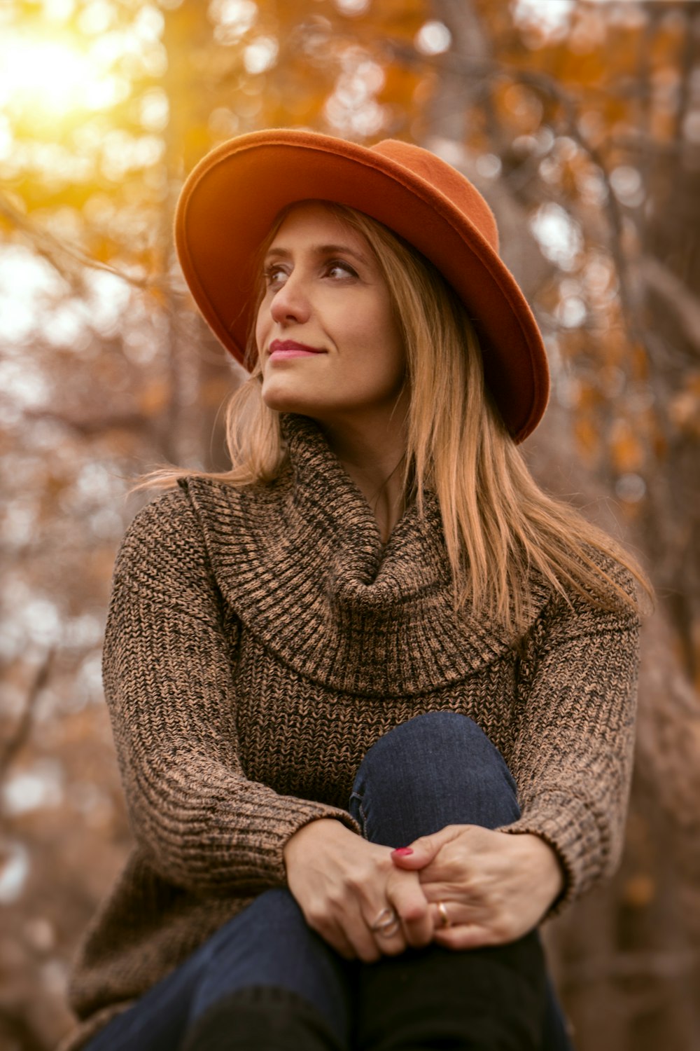 woman wearing brown sweater and orange hat