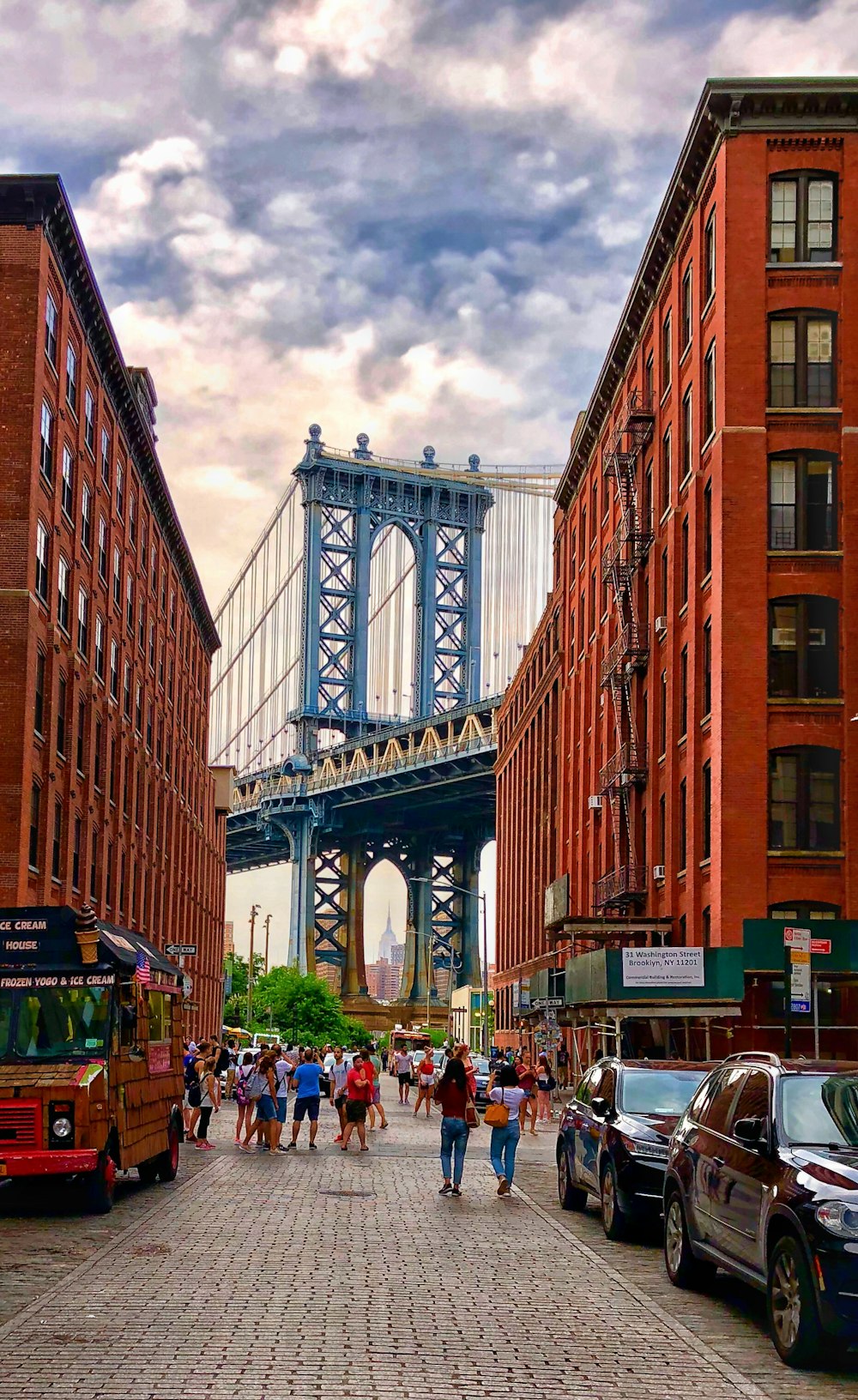 a group of people walking down a street next to tall buildings