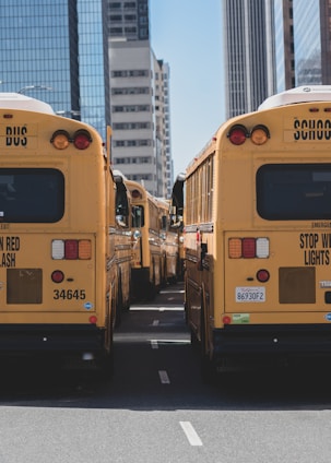 A fleet of modern buses lined up outside an industrial facility in Manisa during sunrise.