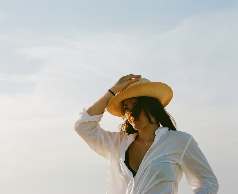 woman holding her hat