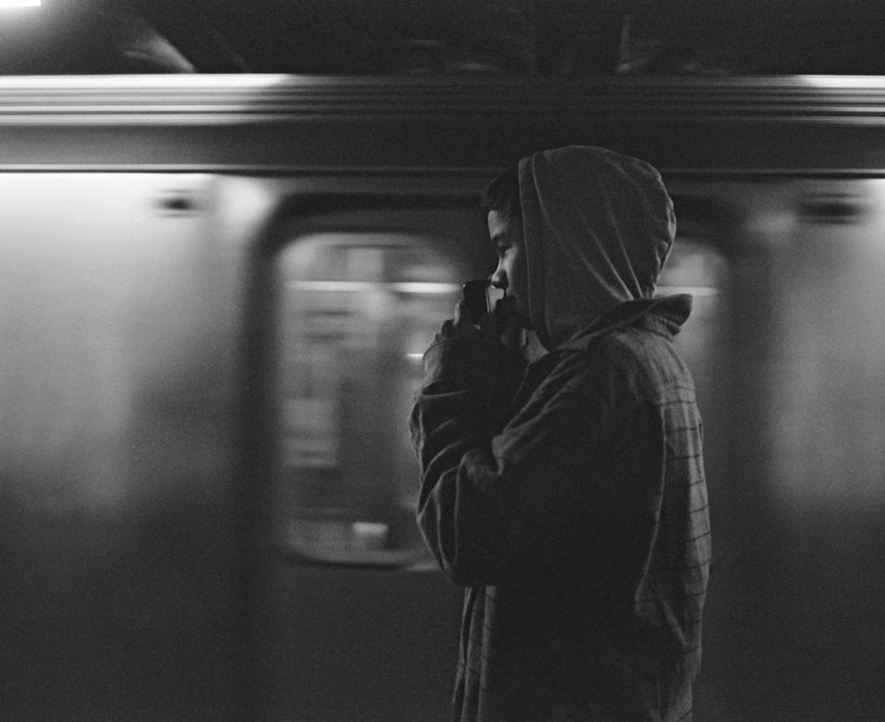 man wearing hoodie near train