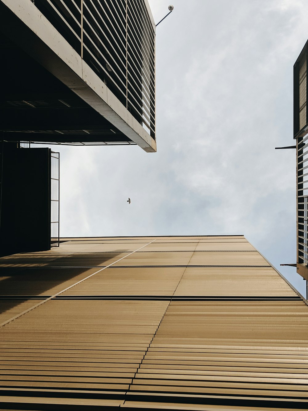 worm's-eye view photo of brown building across clouds