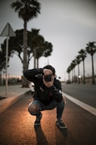 man wearing blue ripped jeans holding DSLR camera