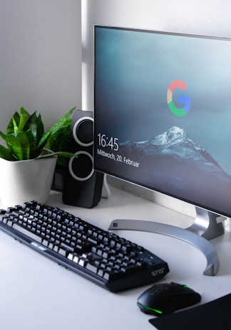 black Logitech G710+ wireless keyboard and wireless mouse near gray flat screen computer monitor on table