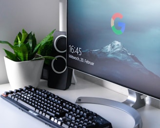 black Logitech G710+ wireless keyboard and wireless mouse near gray flat screen computer monitor on table