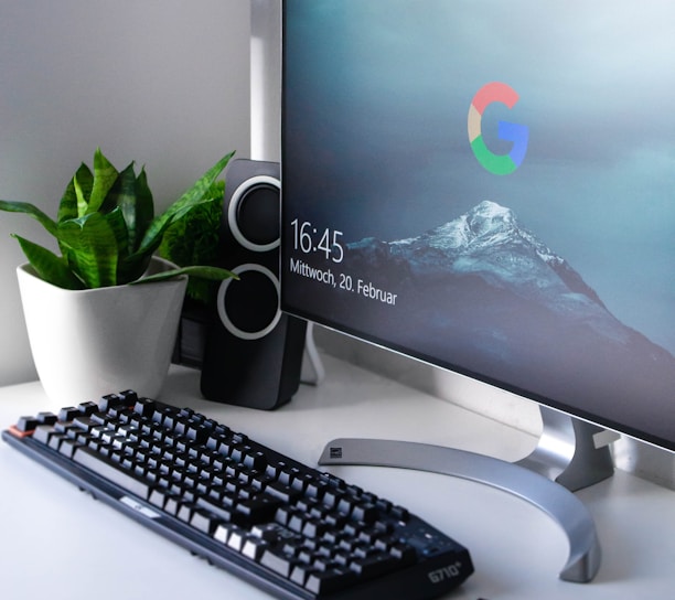 black Logitech G710+ wireless keyboard and wireless mouse near gray flat screen computer monitor on table