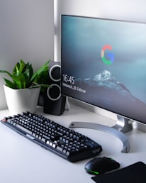 black Logitech G710+ wireless keyboard and wireless mouse near gray flat screen computer monitor on table