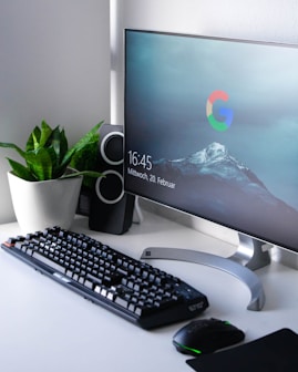 black Logitech G710+ wireless keyboard and wireless mouse near gray flat screen computer monitor on table