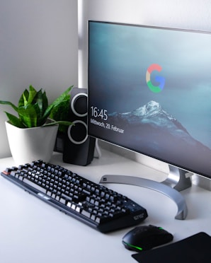 black Logitech G710+ wireless keyboard and wireless mouse near gray flat screen computer monitor on table