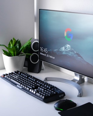 black Logitech G710+ wireless keyboard and wireless mouse near gray flat screen computer monitor on table