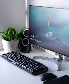 black Logitech G710+ wireless keyboard and wireless mouse near gray flat screen computer monitor on table