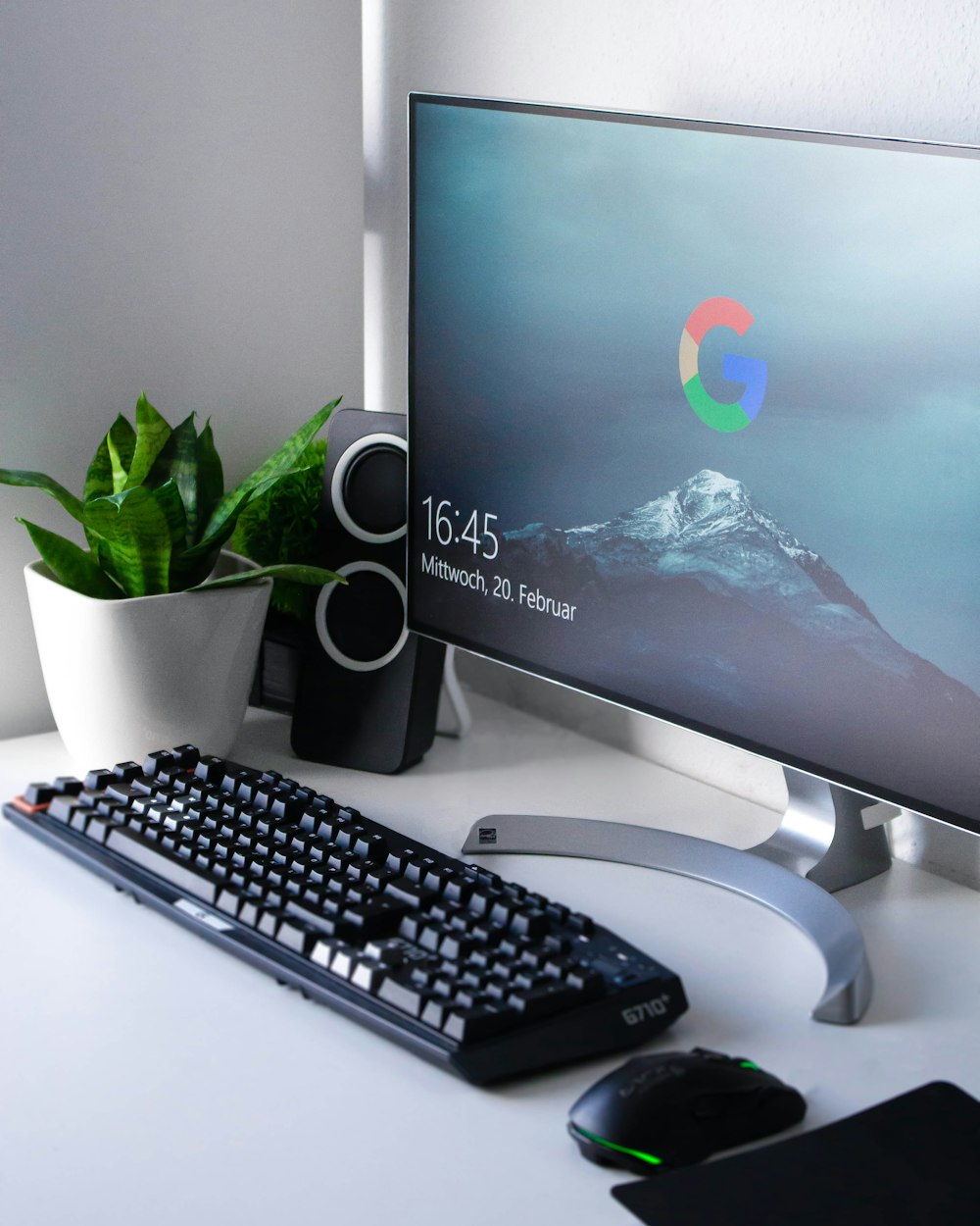 black Logitech G710+ wireless keyboard and wireless mouse near gray flat screen computer monitor on table