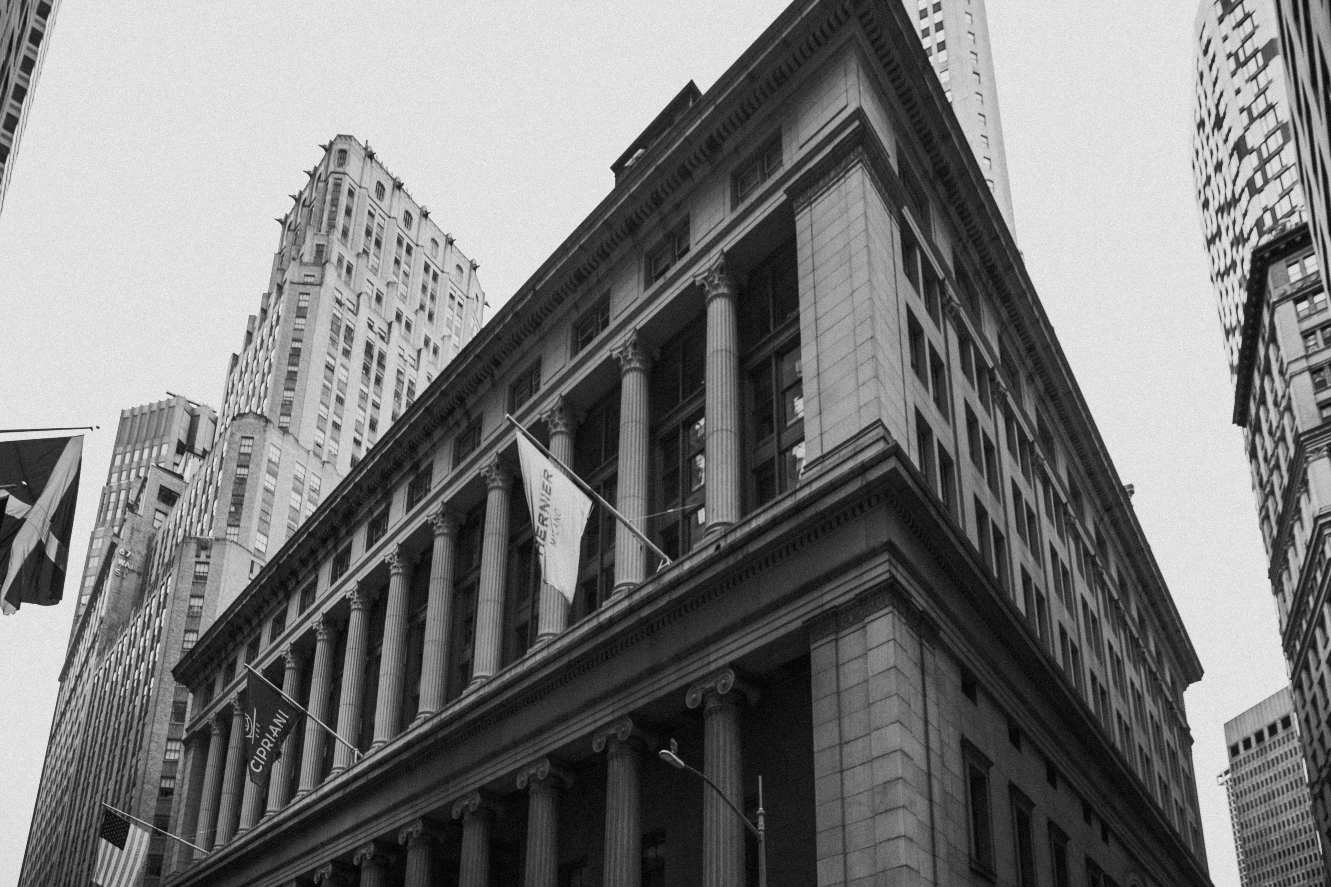 grayscale photography of waving flag hanged on building